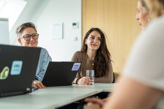 student girl sitting at the desk with laptop and smiling