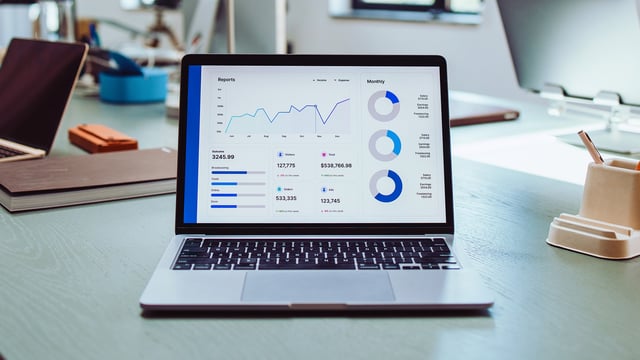 Laptop mit IT-Monitoring-Dashboard auf Schreibtisch – Symbolbild für erfolgreiche Implementierung, individuelle Anpassung und schnellen ROI durch USU Services.