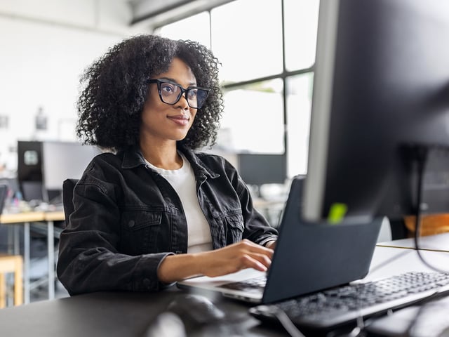 IT-Fachkraft am Arbeitsplatz vor Monitor – Symbolbild für professionelle Beratung, Implementierung und Support im Bereich IT-Monitoring.