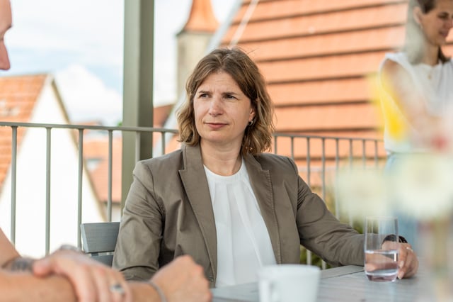 woman with a brown blazer sitting outside