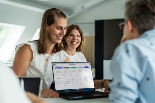 women sitting at a desk and laughing
