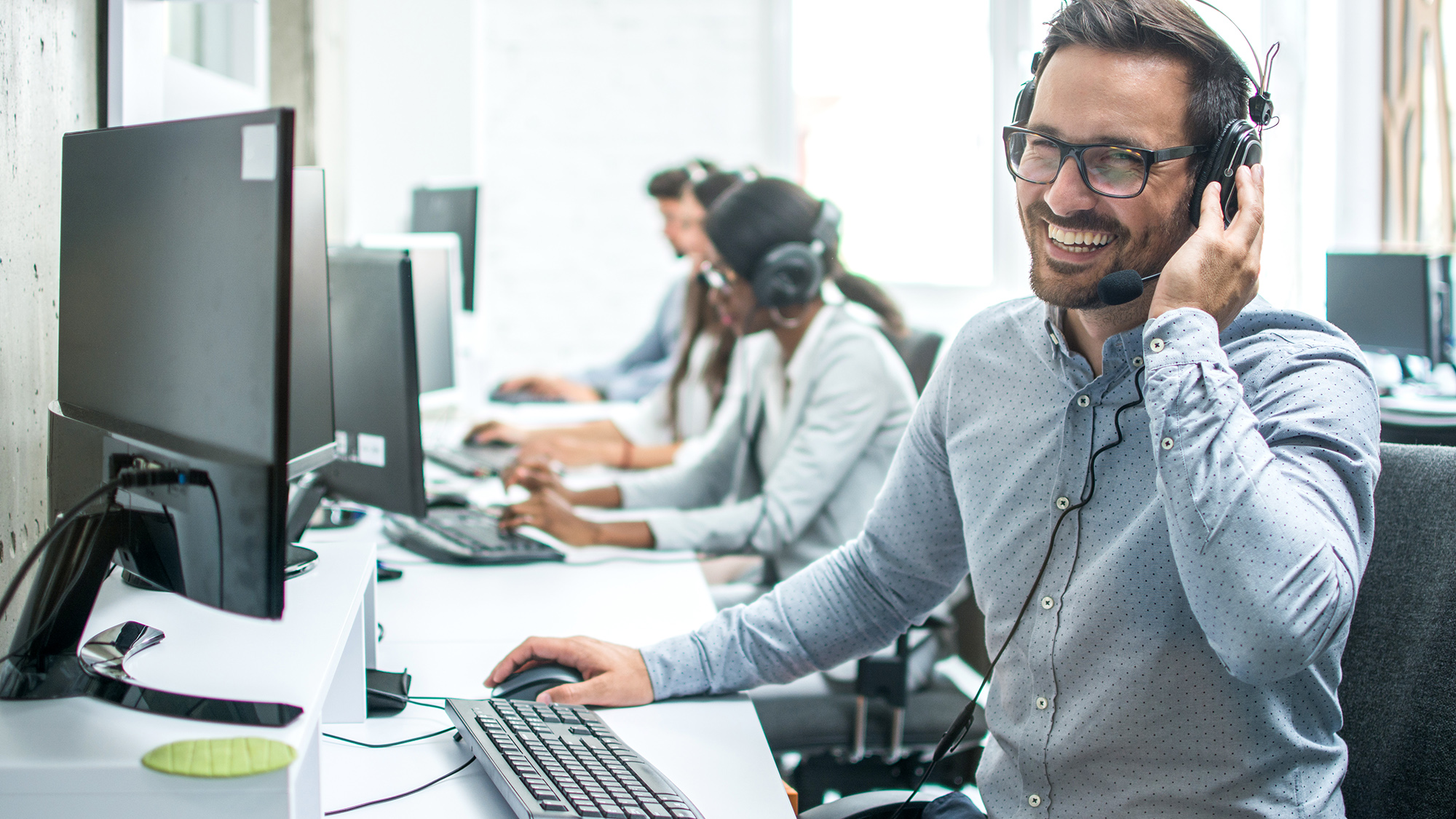 Mann mit Headset am Bildschirm