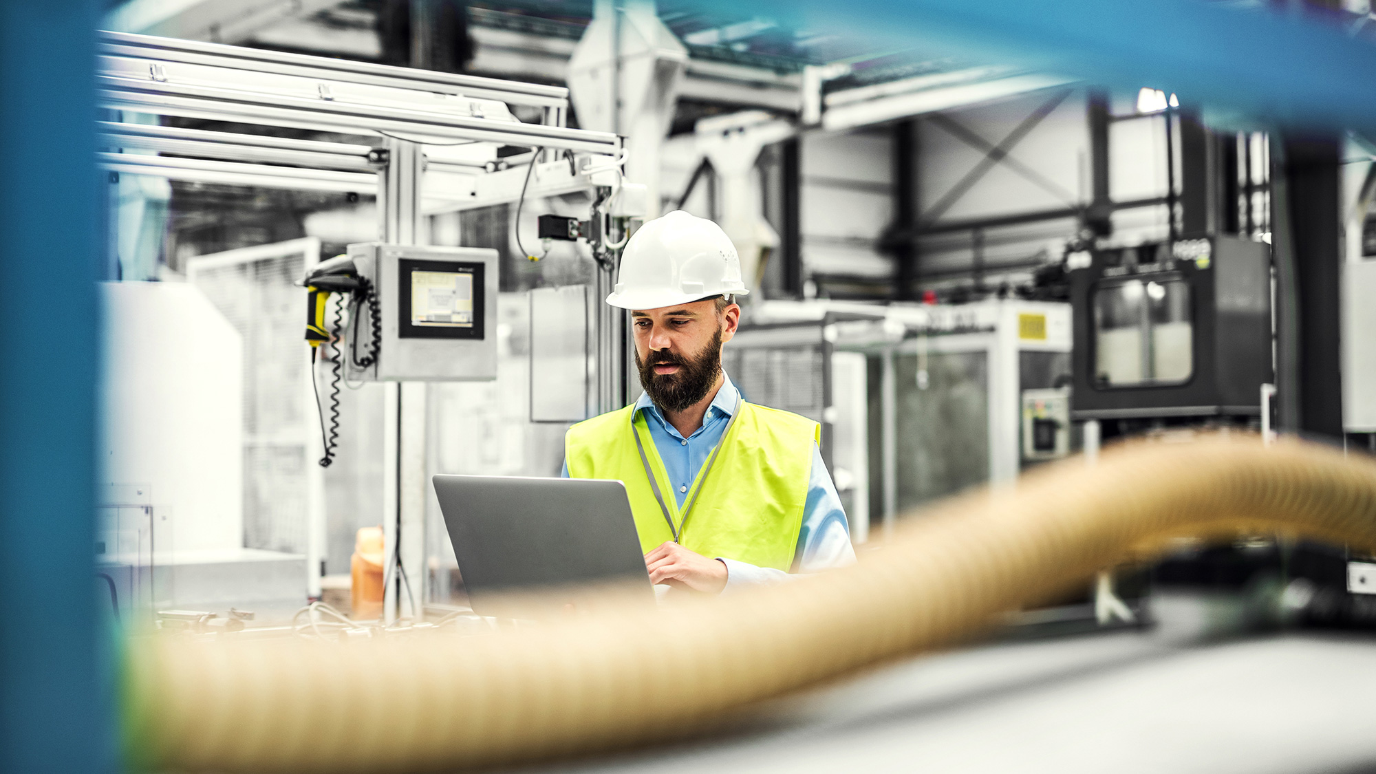 Worker at the laptop between machines