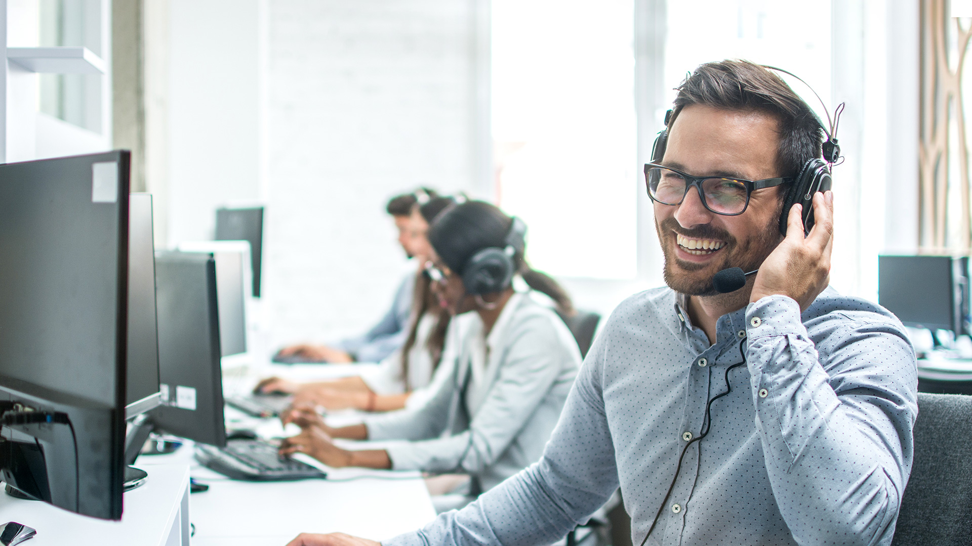 Mann mit Headset am Bildschirm