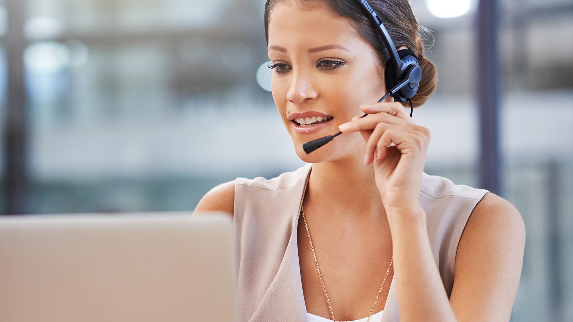 Frau mit Headset am Laptop